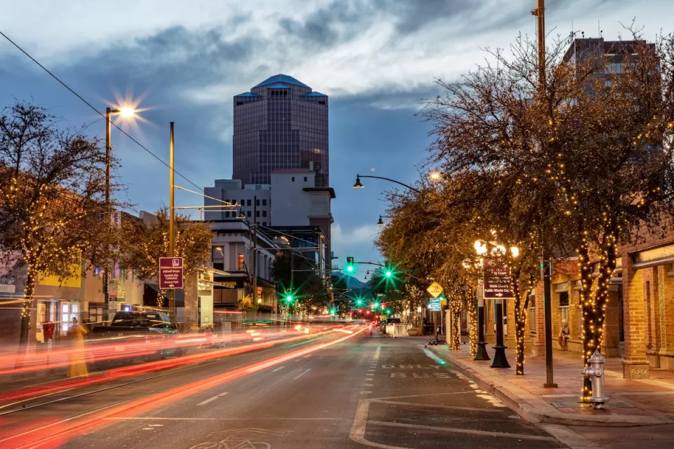 Street with blurred traffic and office buioldings in background in Tucson, Arizona at dusk.